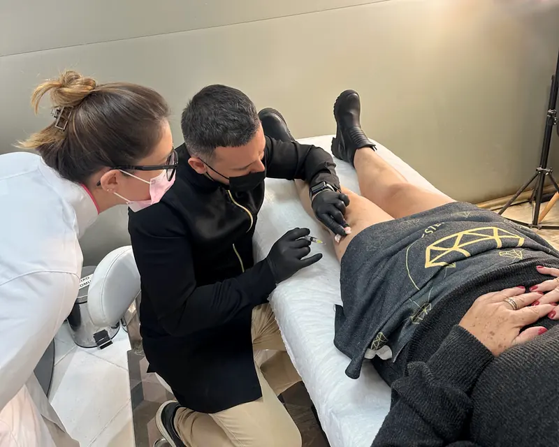 Dr. Marcos Vinicius Lima fazendo um procedimento de vasinhos nas pernas de uma cliente, na sala da Sorelle